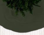Dark green Christmas tree skirt with a white floor and dark green wall background