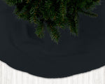 Black Christmas tree skirt with a pine tree on a dark background